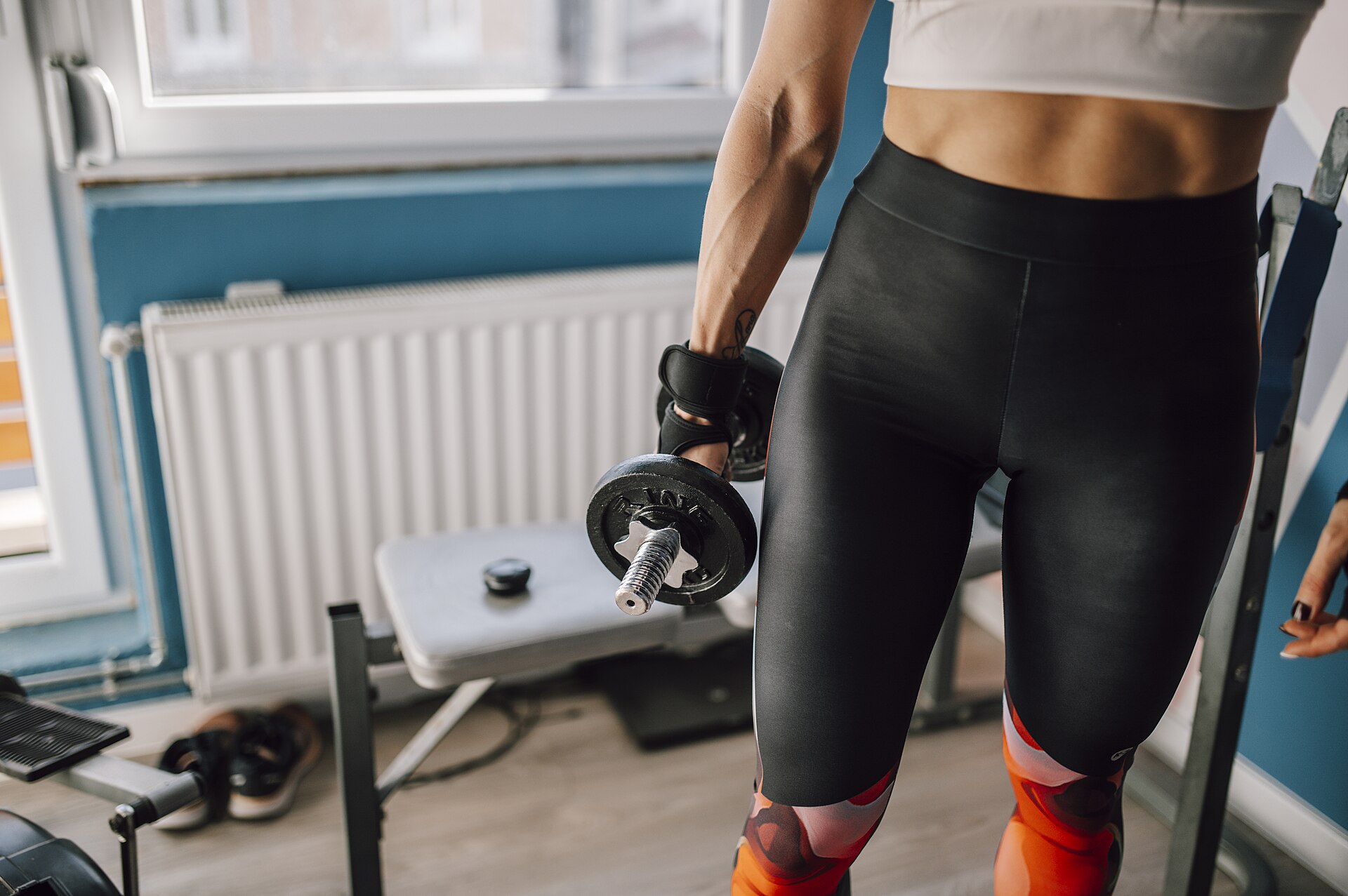 Person holding a dumbbell during a home gym workout